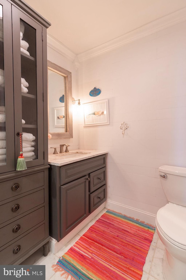 bathroom with tile patterned flooring, toilet, vanity, and ornamental molding