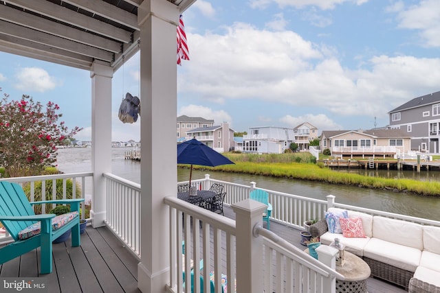 wooden deck featuring an outdoor hangout area and a water view