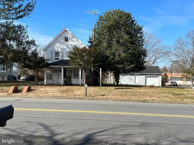 view of front facade featuring a garage, an outbuilding, and a porch