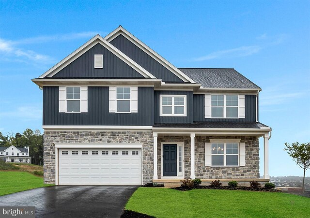 craftsman inspired home featuring a garage and a front yard