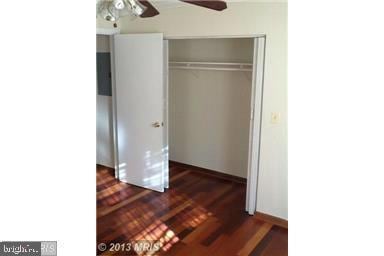 unfurnished bedroom featuring dark hardwood / wood-style flooring, a closet, and ceiling fan