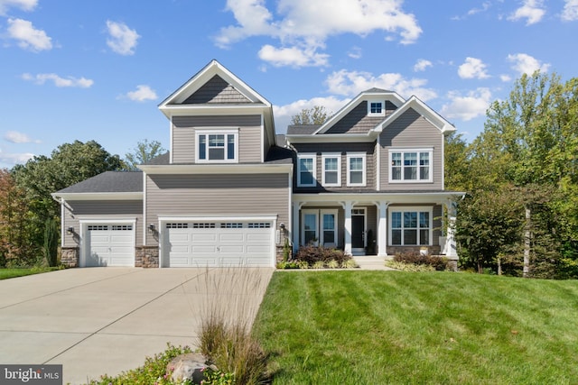 craftsman inspired home with covered porch, a front yard, and a garage