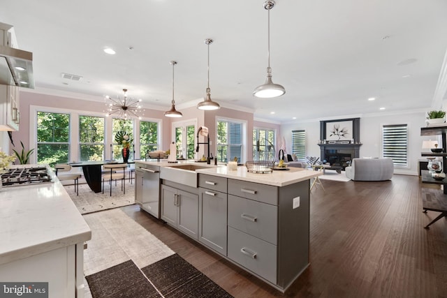 kitchen with pendant lighting, an island with sink, appliances with stainless steel finishes, and light stone countertops