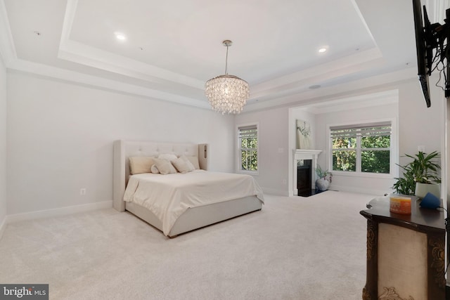 bedroom with a notable chandelier, a tray ceiling, and carpet