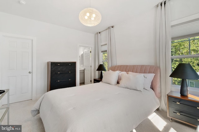 bedroom featuring light carpet and ensuite bath