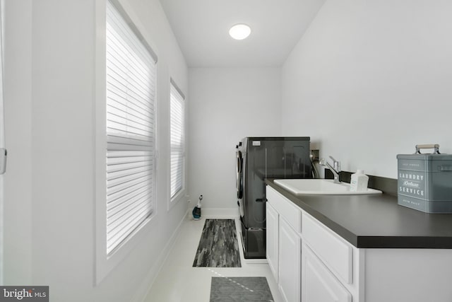 laundry room featuring cabinets, sink, and washer and dryer