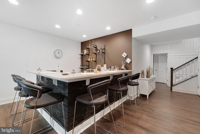 bar with white cabinets and dark hardwood / wood-style floors