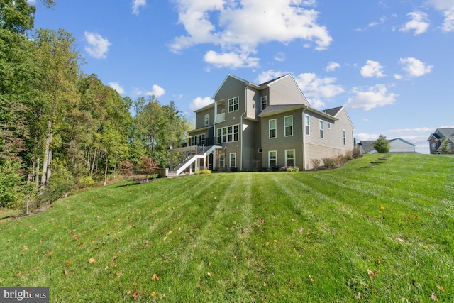 back of property with a deck and a yard