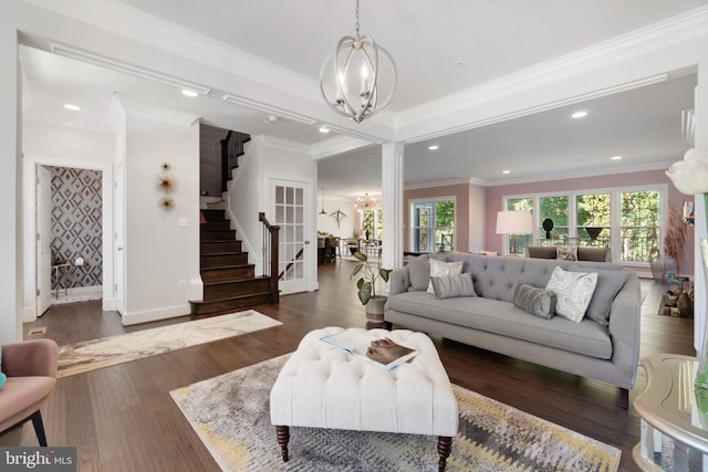 living room with a notable chandelier, ornamental molding, and dark hardwood / wood-style flooring