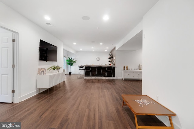 living room with dark hardwood / wood-style floors and bar