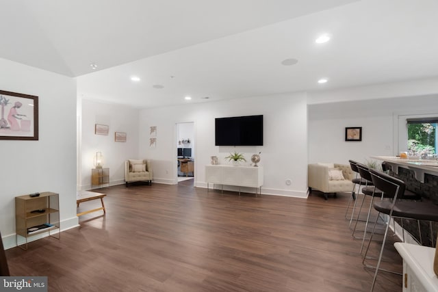 living room featuring dark hardwood / wood-style floors and vaulted ceiling