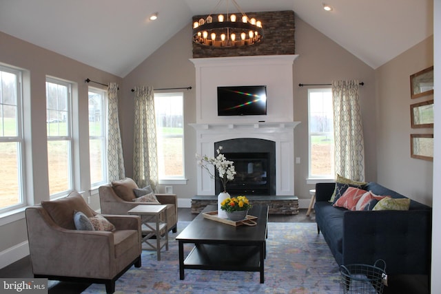 living room with a wealth of natural light, a fireplace, and high vaulted ceiling