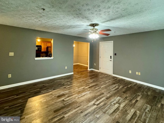 spare room with ceiling fan, a textured ceiling, and dark hardwood / wood-style flooring