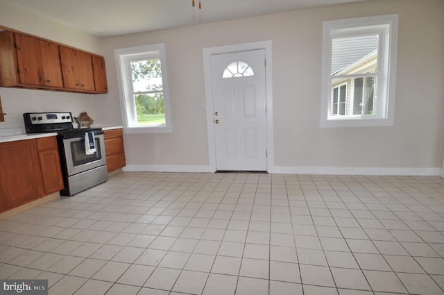 kitchen featuring light tile patterned flooring and stainless steel range with electric cooktop