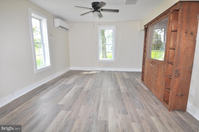 entrance foyer with a healthy amount of sunlight, a wall unit AC, and light wood-type flooring