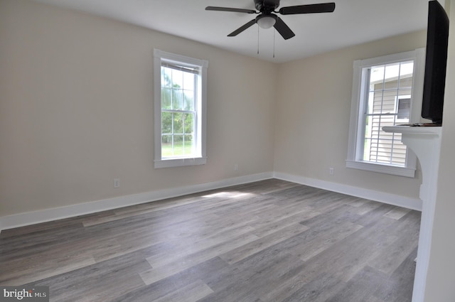 unfurnished room with ceiling fan, a healthy amount of sunlight, and light wood-type flooring