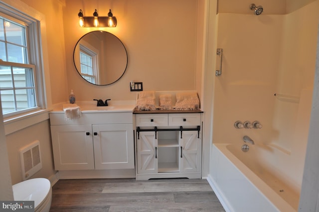 full bathroom with wood-type flooring, a healthy amount of sunlight, bathing tub / shower combination, and vanity