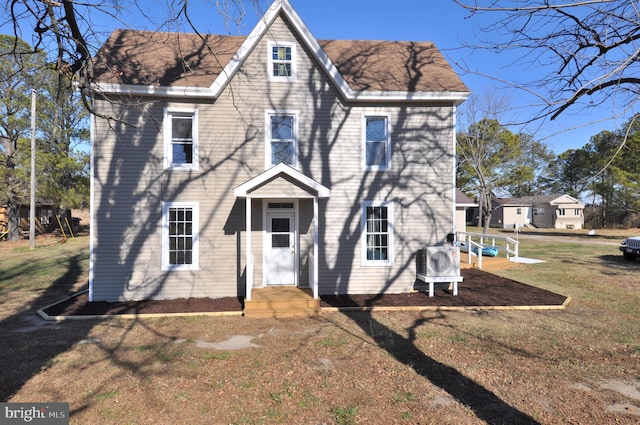 rear view of property featuring a yard