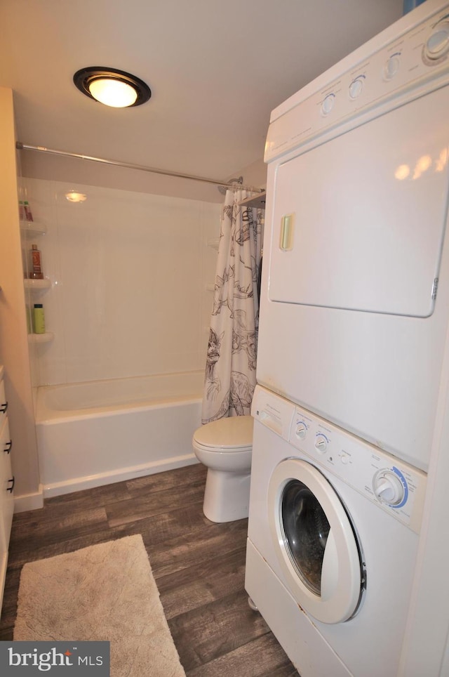 laundry room featuring stacked washing maching and dryer and dark hardwood / wood-style floors