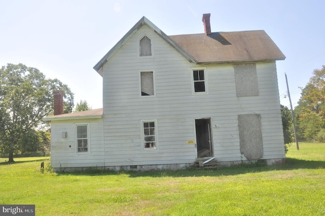 rear view of property with a lawn