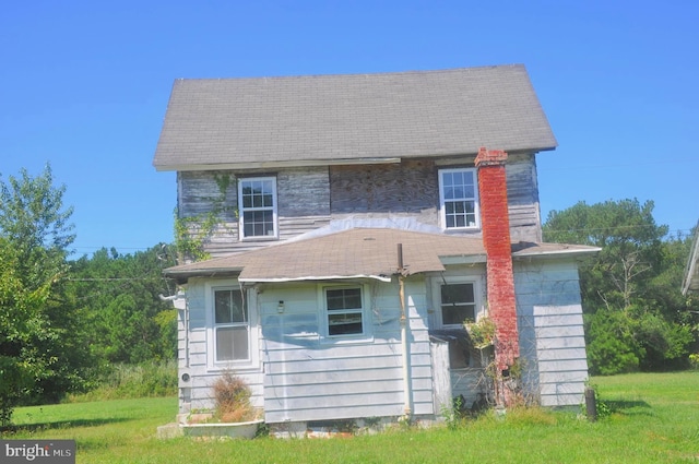 rear view of house featuring a yard