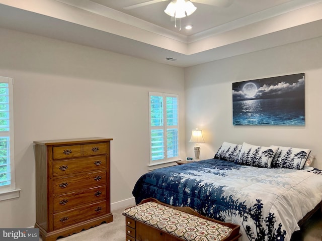 carpeted bedroom featuring ornamental molding, a raised ceiling, and ceiling fan