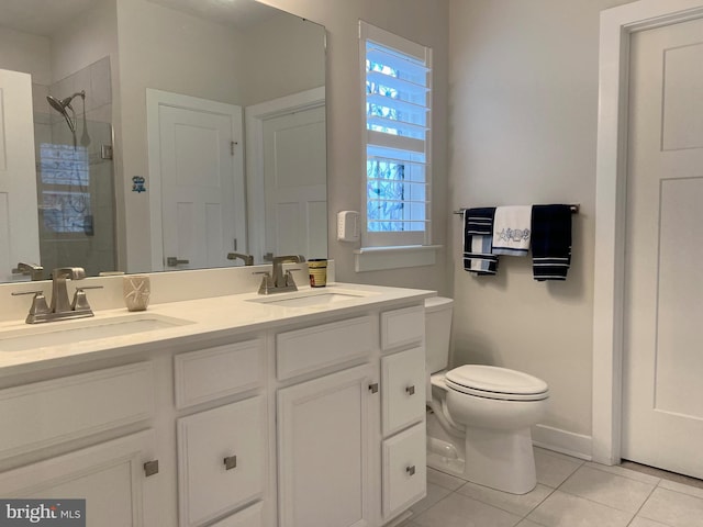 bathroom featuring tile patterned floors, toilet, a shower with door, and vanity