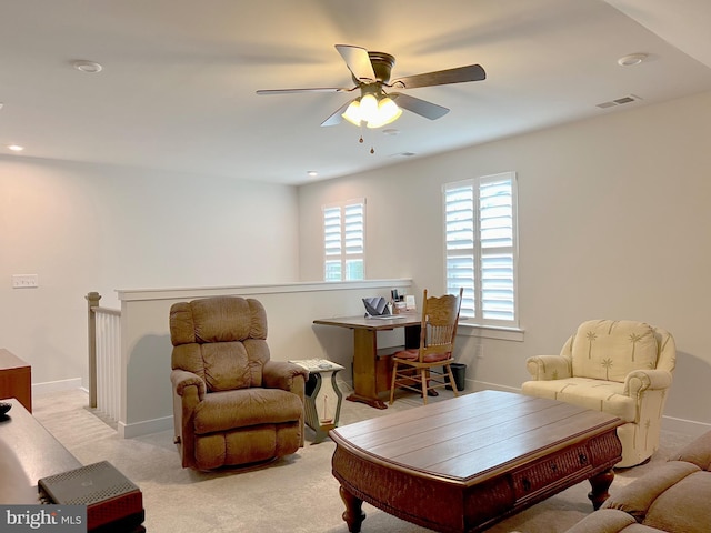 living area featuring light colored carpet and ceiling fan