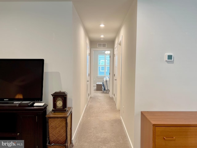 hall featuring light colored carpet