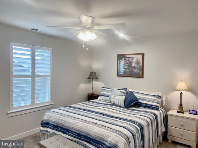 bedroom with ceiling fan, carpet floors, and multiple windows