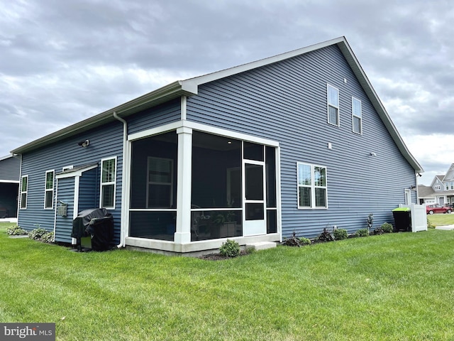 rear view of property with a sunroom and a yard