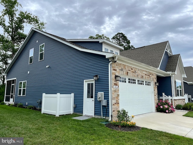 view of side of property featuring a garage and a lawn