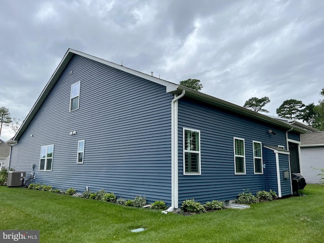 view of home's exterior with central AC unit and a lawn