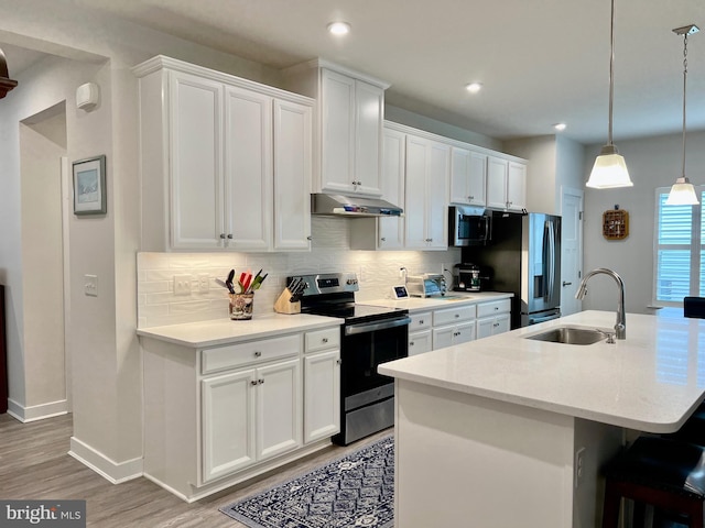 kitchen featuring a kitchen island with sink, sink, stainless steel appliances, and white cabinets