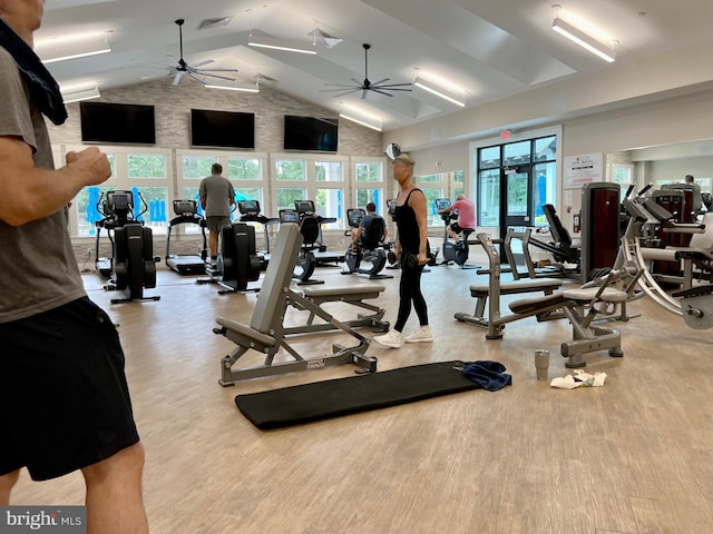 gym featuring ceiling fan, lofted ceiling, and light wood-type flooring