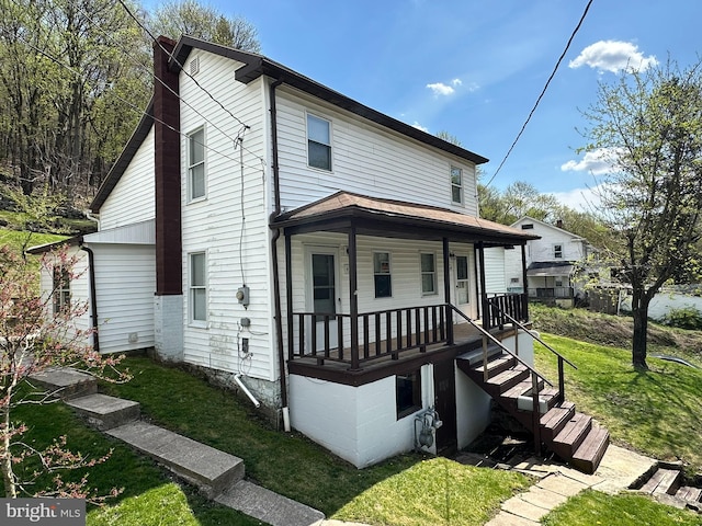 view of front of home featuring covered porch and a front lawn