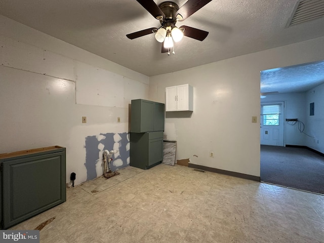 empty room with ceiling fan and a textured ceiling