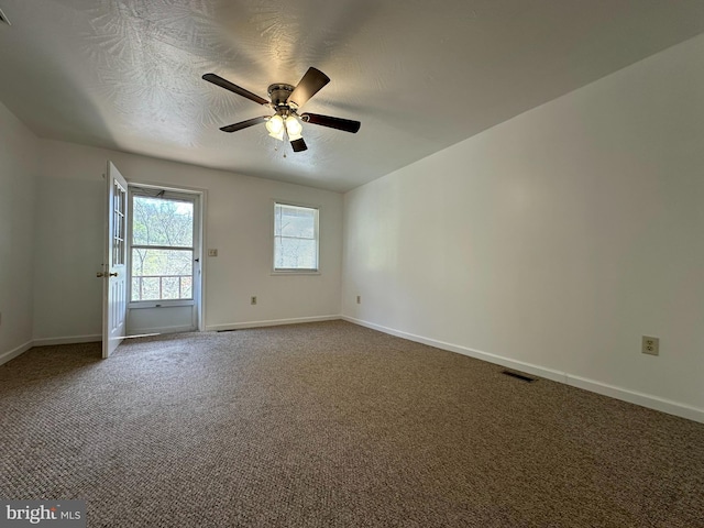 carpeted empty room featuring ceiling fan and a textured ceiling