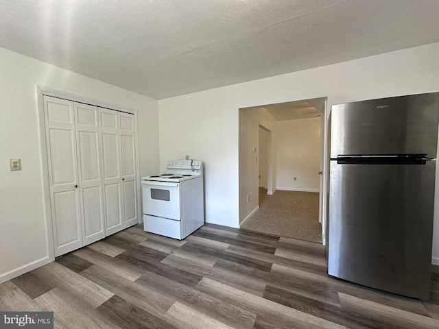 kitchen featuring electric stove, hardwood / wood-style flooring, and stainless steel refrigerator