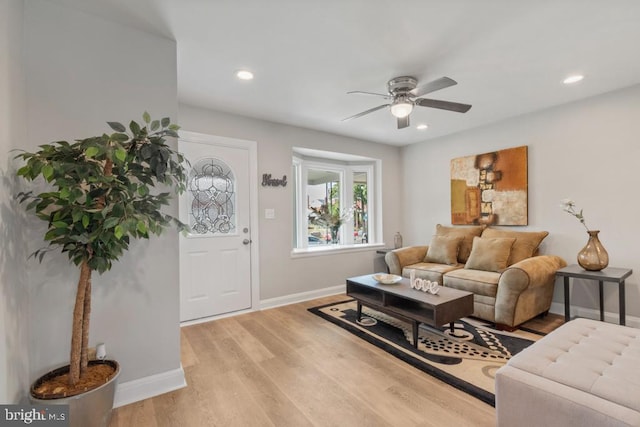 living room with light wood-type flooring and ceiling fan