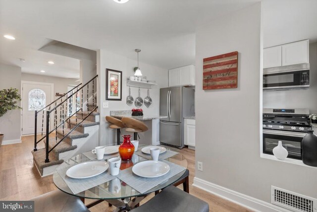 kitchen with dark wood-type flooring, sink, white cabinetry, stainless steel appliances, and light stone countertops