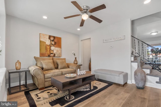 living room featuring light hardwood / wood-style flooring and ceiling fan