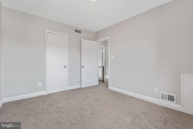 unfurnished room with carpet and vaulted ceiling