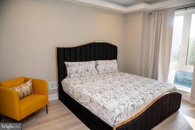 bedroom featuring multiple windows and light hardwood / wood-style flooring