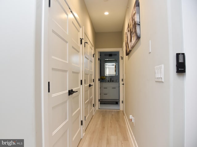 corridor featuring sink and light hardwood / wood-style flooring