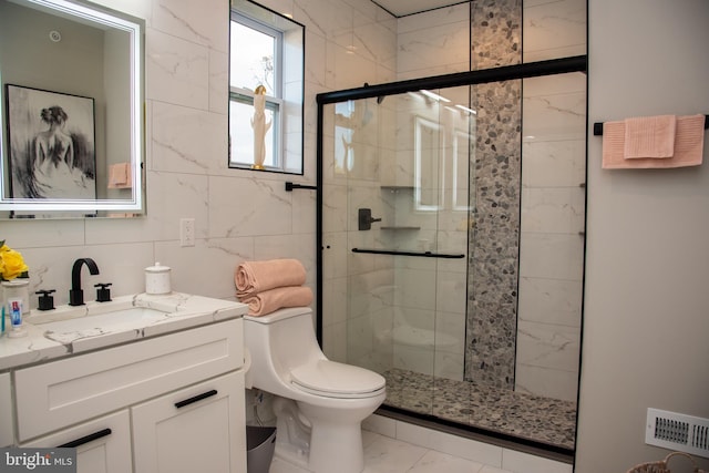 bathroom featuring a shower with door, toilet, vanity, tile walls, and tile patterned floors