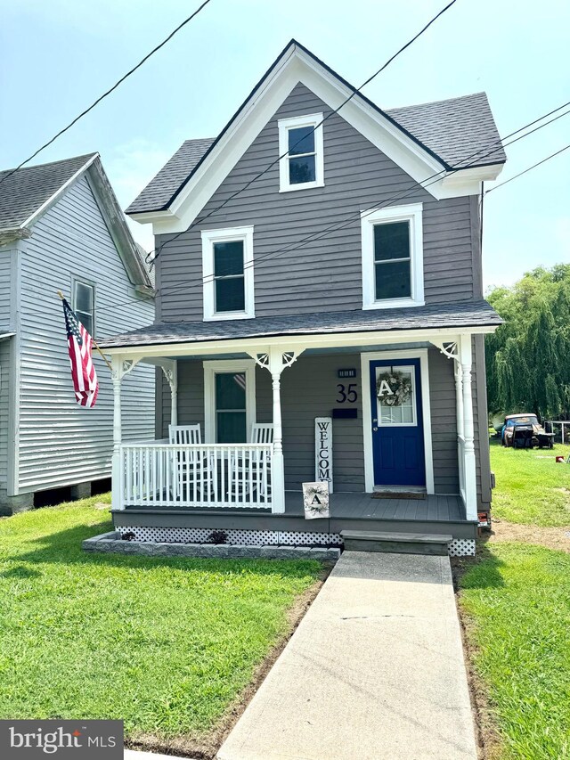 view of front of house with a porch and a front yard