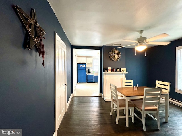 dining area with dark wood-type flooring and ceiling fan