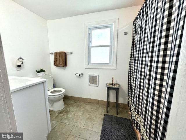 bathroom featuring vanity, toilet, and heating unit