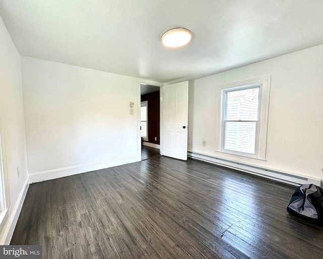 empty room with a baseboard radiator and dark hardwood / wood-style floors